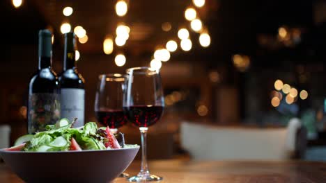 Salad-and-wine-panning-shot-at-night-restaurant