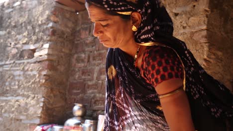 Auténtica-Vida-Rural-Real-De-Una-Mujer-India-Pobre-Cocinando-Al-Aire-Libre-Con-Una-Olla-Y-Una-Cuchara-Rústicas