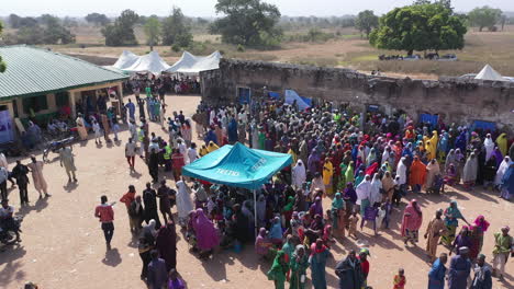 Vista-Aérea-De-Una-Multitud-De-Personas-En-Agwara,-Nigeria,-Que-Reciben-Asistencia-Humanitaria-En-La-Estación-Del-Gobierno-Local