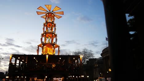 Christmas-market-festive-illuminated-rotating-carousel-windmill-against-dark-evening-sky