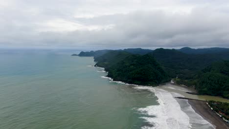Air-view-of-green-hills-and-Suwuk-beach-in-Kebumen,-Indonesia