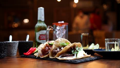 Mexikanisches-Essen-Am-Abend-Im-Restaurant,-Tacos,-Bier,-Quesadilla,-Gringas,-Salsas,-Michelada,-Schwenken