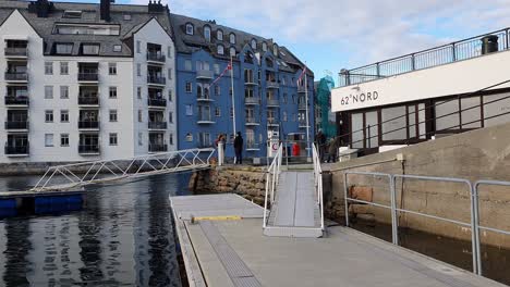 Turistas-Caminando-En-El-Paseo-Marítimo-Del-Puerto-De-Alesund,-Noruega