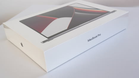 Neue-Apple-M1-MacBook-Pro-Box-Dreht-Sich-Auf-Weißem-Schreibtisch