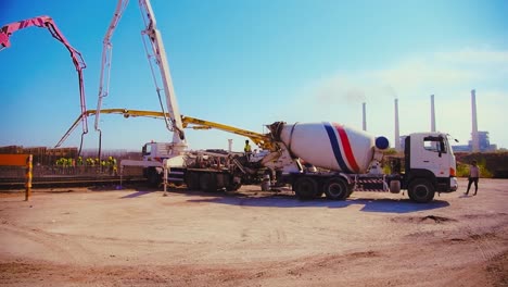 Establishing-shot-of-a-construction-site-while-concrete-mixer-trucks-moving-around