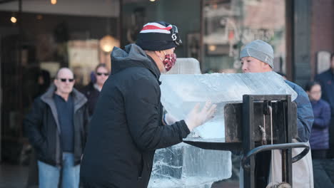 Handheld-shot-of-artists-lifting-large-block-of-ice