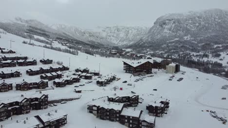 Flug-über-Teure-Freizeithäuser-In-Myrkdalen-Norwegen-An-Einem-Verschneiten-Morgen-Mit-Hotel-Und-Berg-Vikafjellet-Im-Hintergrund---Luftaufnahme