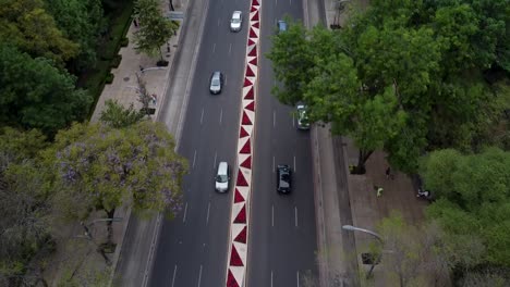 Vista-Aérea-Sobre-El-Tráfico-En-La-Avenida-Paseo-De-La-Reforma-Con-Decoración-De-Flores-De-Pascua-En-La-Mediana,-Ciudad-De-México