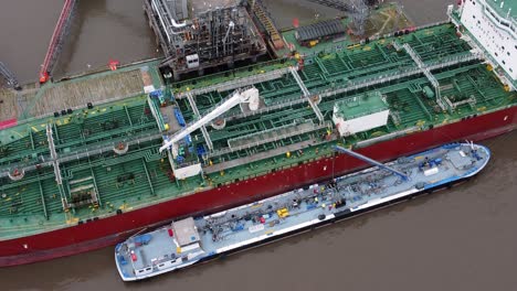Silver-Rotterdam-oil-petrochemical-shipping-tanker-loading-at-Tranmere-terminal-Liverpool-aerial-closeup-tilt-down-view