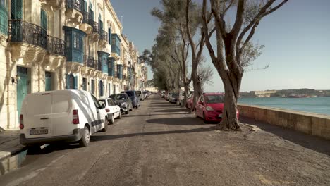 Caminando-En-Valletta-En-Un-Día-Soleado-Con-árboles-Proyectando-Sombras-En-La-Calle-Cerca-Del-Mar