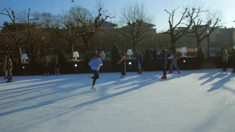 Vista-De-Una-Gran-Multitud-De-Personas-Haciendo-Patinaje-Sobre-Hielo-Cerca-Del-Flevopark-En-Un-Lago-Congelado-En-Amsterdam-Durante-La-Temporada-De-Invierno,-Navidad-En-Países-Bajos