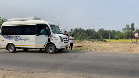 A-white-traveler-van-standing-in-a-village-road-in-India-during-morning-time-in-rural-Bengal