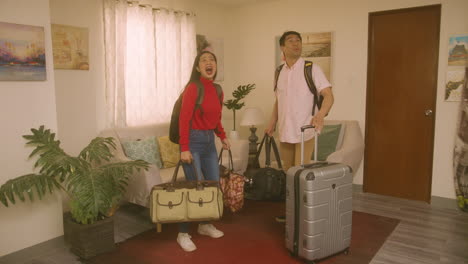 A-Young-Couple-With-Luggage,-Surprised-With-Their-New-House