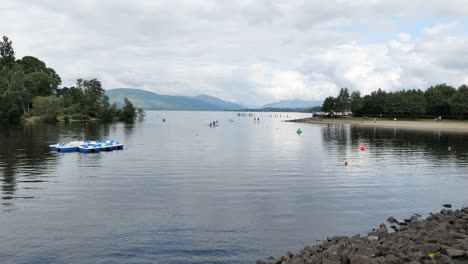 Landschaft-Mit-Menschen,-Die-Auf-Paddleboards-Auf-Dem-Loch-Lomond-In-Schottland-Rudern,-Aktiver-Lebensstil-Und-Wassersport