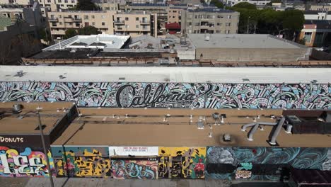 Luftaufnahme-Weg-Von-Einer-Wand-Mit-Dem-Text-Kalifornien-Und-Graffiti,-Im-Sonnigen-San-Francisco,-USA-–-Zurückziehen,-Drohnenaufnahme