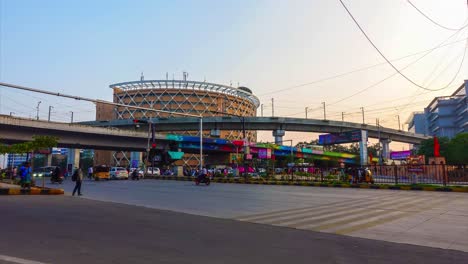 Zeitrafferaufnahme-Der-Wunderschönen-High-Tech-Stadt-Hyderabad-Mit-Einem-Hohen-Gebäude-Vor-Der-Brücke-Und-Den-Menschen-In-Fahrzeugen,-Die-Sich-Auf-Der-Straße-Bewegen