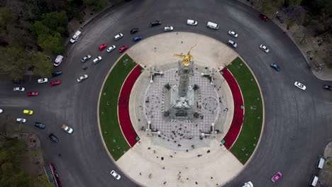 Toma-Aérea-De-Autos-Que-Rodean-La-Rotonda-Del-ángel-De-La-Independencia-En-El-Paseo-De-La-Reforma,-Ciudad-De-México