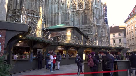 People-enjoying-Christmas-Market-at-stands-in-first-district-of-Vienna,-Austria