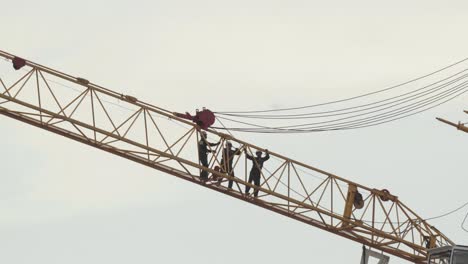 Una-Foto-De-Trabajadores-De-La-Construcción-Tailandeses-Montando-Una-Grúa-En-El-Sitio-De-Un-Nuevo-Desarrollo,-Los-Hombres-Tirando-De-Cables-Pesados-Que-Operan-El-Brazo-De-La-Grúa-En-Pathum-Thani,-Tailandia