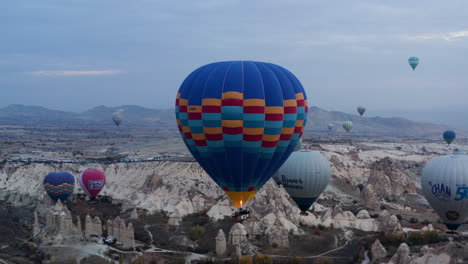 Tourists-On-Hot-Air-Balloons-Flying-Over-Fairy-Chimneys-At-Sunrise-In-Cappadocia,-Turkey