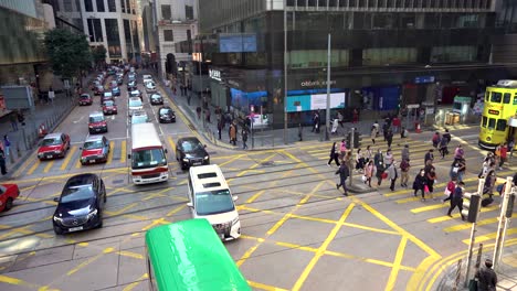 Tráfico-De-Automóviles-Y-Multitud-De-Peatones-Cruzando-La-Concurrida-Calle-De-Hong-Kong