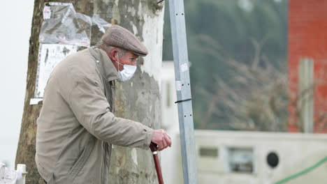 Senior-Man-With-Medical-Mask-Standing-On-Sidestreet-During-Pandemic-In-Leiria-City,-Portugal