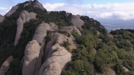 Asombrosa-Vista-Aérea-Del-Paisaje-Montañoso-De-Montserrat,-Barcelona,-España,-Drone-Volando-Hacia-Corredores-De-Maratón,-Durante-El-Día