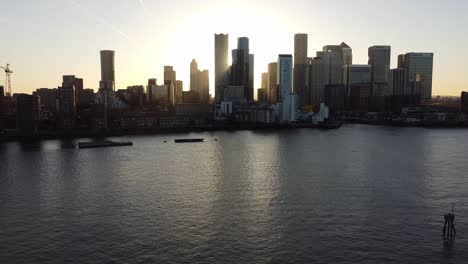Aerial---Sunset-over-River-Thames-and-Canary-Wharf,-London,-wide-backward-shot