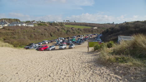 Cornish-Crantock-beach-parking,-outdoor-car-park-full-of-activity,-wide-shot