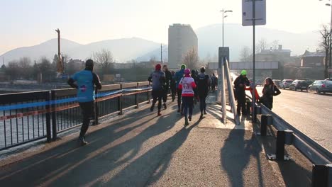 Group-of-sprinters-running-a-marathon-through-the-bridge-in-cold-January-morning
