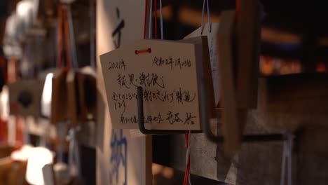 Beautiful-mysterious-wooden-wishing-cards-at-typical-Japanese-shrine-close-up-Slow-motion