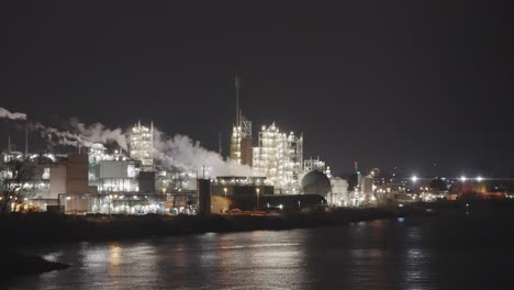 View-Of-Dordrecht-Dupont-Chemical-Plant---Polluting-toxic-factory-smoke-At-Night-From-Across-Beneden-Merwede-River---teflon-forever-chemicals