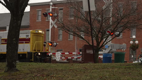 Cargo-train-passing-through-downtown-Lewisburg-Pennsylvania-in-winter,-Slow-Motion