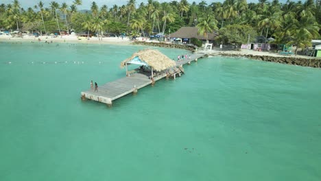 Aerial-view-of-girls-taking-selfie-on-the-jetty-of-Pigeon-Point,-Tobago-on-the-Caribbean-island-of-Tobago