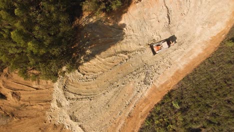 4K-aerial-view-of-a-bulldozer-moving-some-earth-in-the-middle-of-the-forest