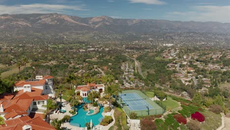 Aerial-flyover-of-a-mansion-on-top-of-a-mountain,-with-a-scenic-view