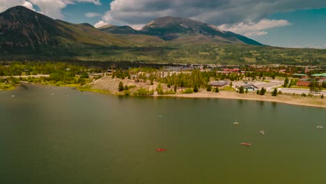 Canoes,-kayaks,-and-paddle-boards-on-Dillon-Reservoir-with-the-mountains-and-Frisco,-Colorado-in-the-background,-cloudscape-overhead-aerial-hyper-lapse