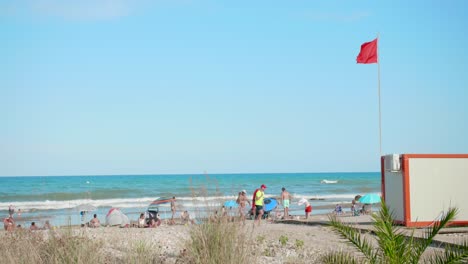 Touristen-Am-Strand-In-Spanien-Im-Sommer-Mit-Roter-Warnflagge