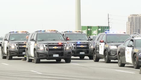 Muchos-Coches-De-Policía-Canadienses-Con-Luces-De-Emergencia-Estacionados-En-La-Carretera-Principal