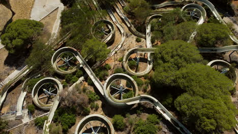 Grungy-Water-Slides-In-An-Old-Abandoned-Waterpark-With-Vegetation