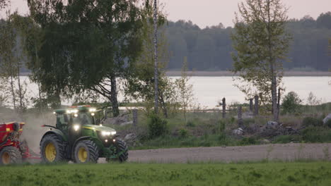 Sowing-pea-and-oat-seeds-at-dusk-in-front-of-a-lake,-Sweden