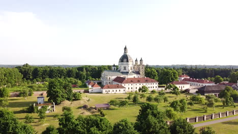 Pazaislis-monastery-complex-building-with-majestic-dome-in-descend-behind-bush-drone-view