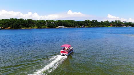 Drohne-Umkreist-Ein-Pontonboot,-Das-Auf-Wunderschönem-Blauen-Wasser-Durch-Den-Sound-An-Einigen-Kleinen-Inseln-In-Der-Nähe-Von-Destin-Florida-Vorbeifährt