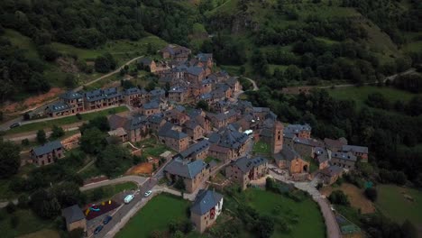 Horizontale-4K-Luftaufnahmen-Eines-Kleinen-Spanischen-Dorfes-Mit-Häusern-In-Einer-Grünen-Natürlichen-Umgebung-In-Den-Spanischen-Pyrenäen