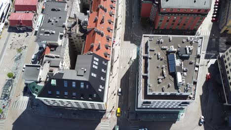 Top-down-birds-eye-view-of-Strandgaten-street-in-Bergen-Norway---Summer-day-aerial-over-rooftops-with-moving-people-and-traffic