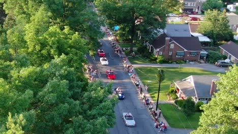 Massen-Von-Nicht-Erkennbaren-Menschen-Säumen-Die-Straßen-Der-Paraderoute-In-Einer-Kleinen-Amerikanischen-Stadt,-Während-Schwebende-Fahrzeuge-In-Der-Historischen-Amerikanischen-Stadt-Vorbeifahren