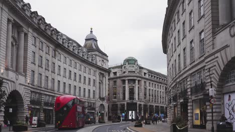 London---Empty-Streets---Regent-Street-with-boarded-up-shops,-red-buses,-and-cars-passing