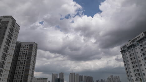 Urban-time-lapse-featuring-dramatic-tropical-storm-and-rain-clouds,-high-rise-apartment-buildings,-and-interesting-moving-highlights-and-shadows