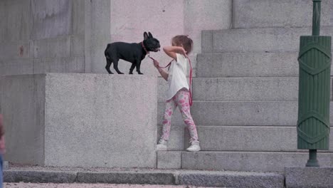 Statische-Slomo-Aufnahme-Eines-Kleinen-Mädchens,-Das-Mit-Seiner-Französischen-Bulldogge-Spielt