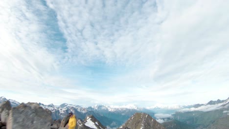 Aerial-drone-fly-by-over-mountain-top-with-FPV-drone-close-to-aletsch-glacier,-Switzerland-with-3-people-standing-on-mountain-top